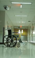 A wheelchair sitting in the hallway of a hospital is shown.